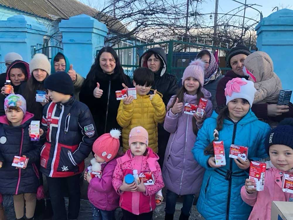 Kids holding their donated food, toys and medicine in Ukraine